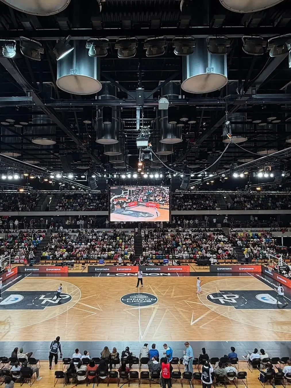 Live event production for London Lions home game at Copper Box Arena with full lighting rig, LED screens and packed crowd