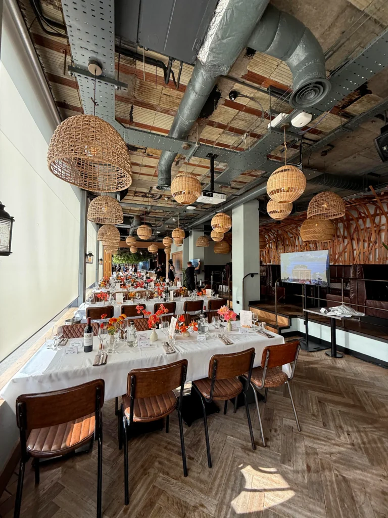 Corporate dinner event at Treehouse London with long banquet tables, presentation screen and professional AV setup