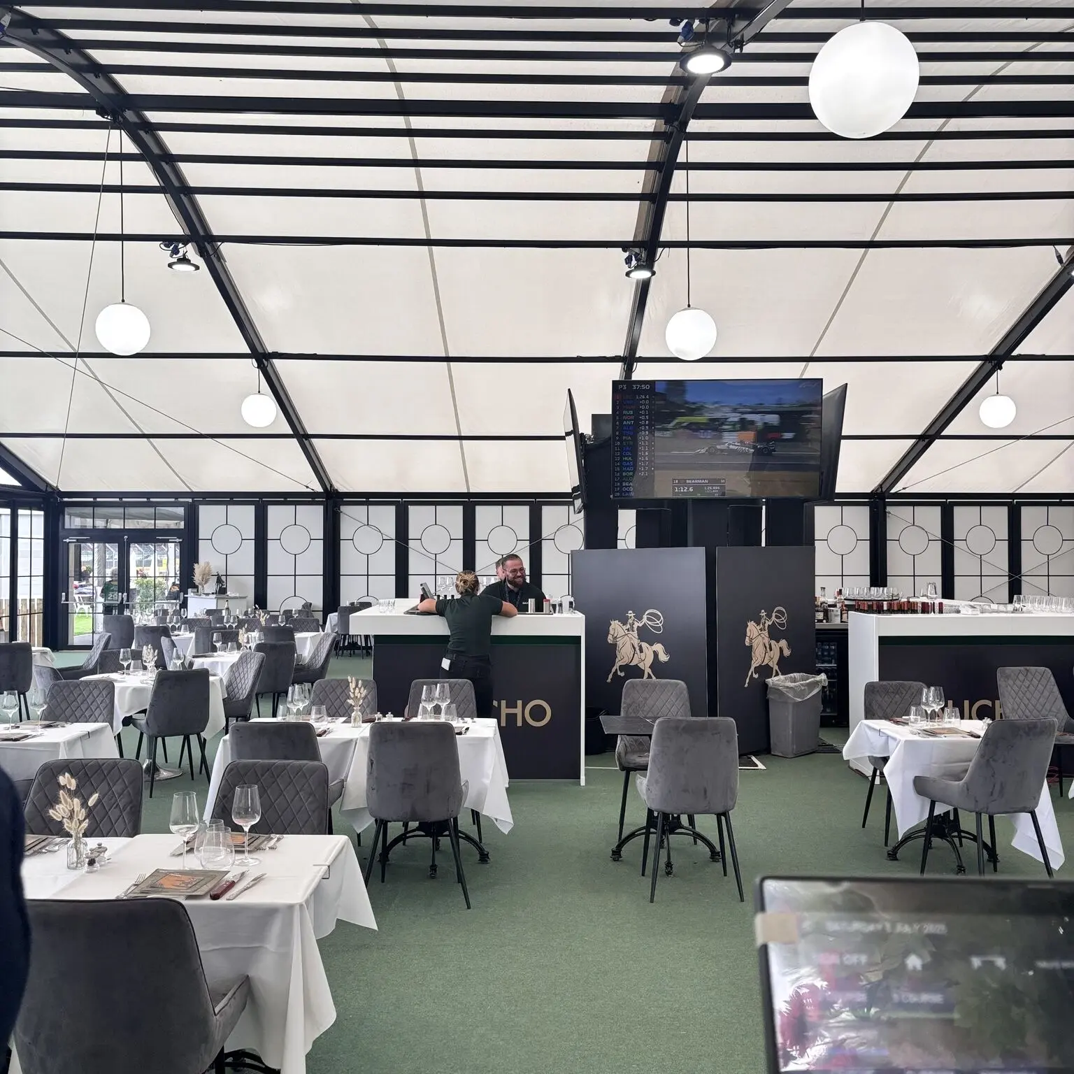 Gaucho popup restaurant interior with AV screen installation and hospitality bar setup at British Grand Prix event