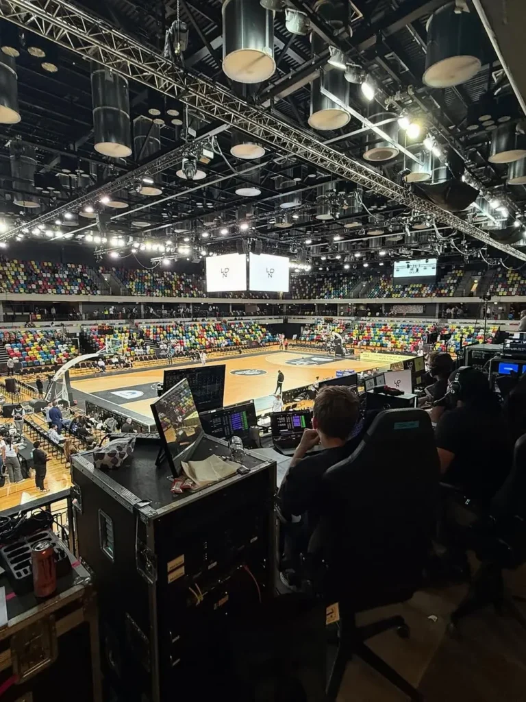Live sports AV production control position managing lighting, video and sound at London arena basketball event