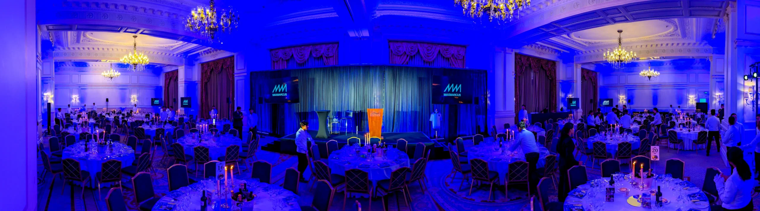Gala dinner event lighting setup at The Landmark London with blue uplighting and stage production