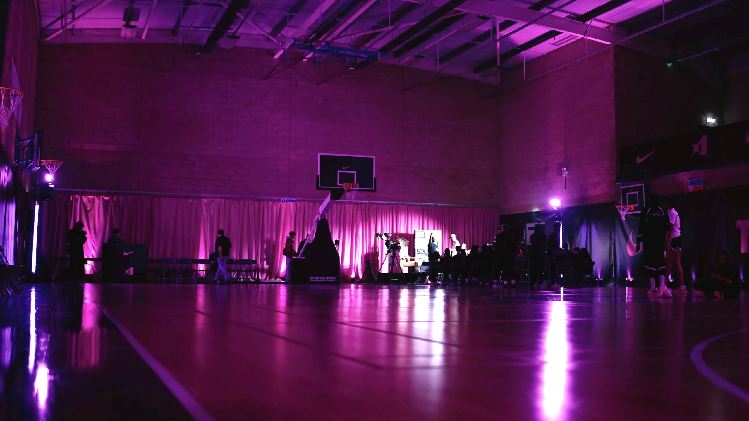 Wide shot of basketball arena transformed with lighting and production for Nike event