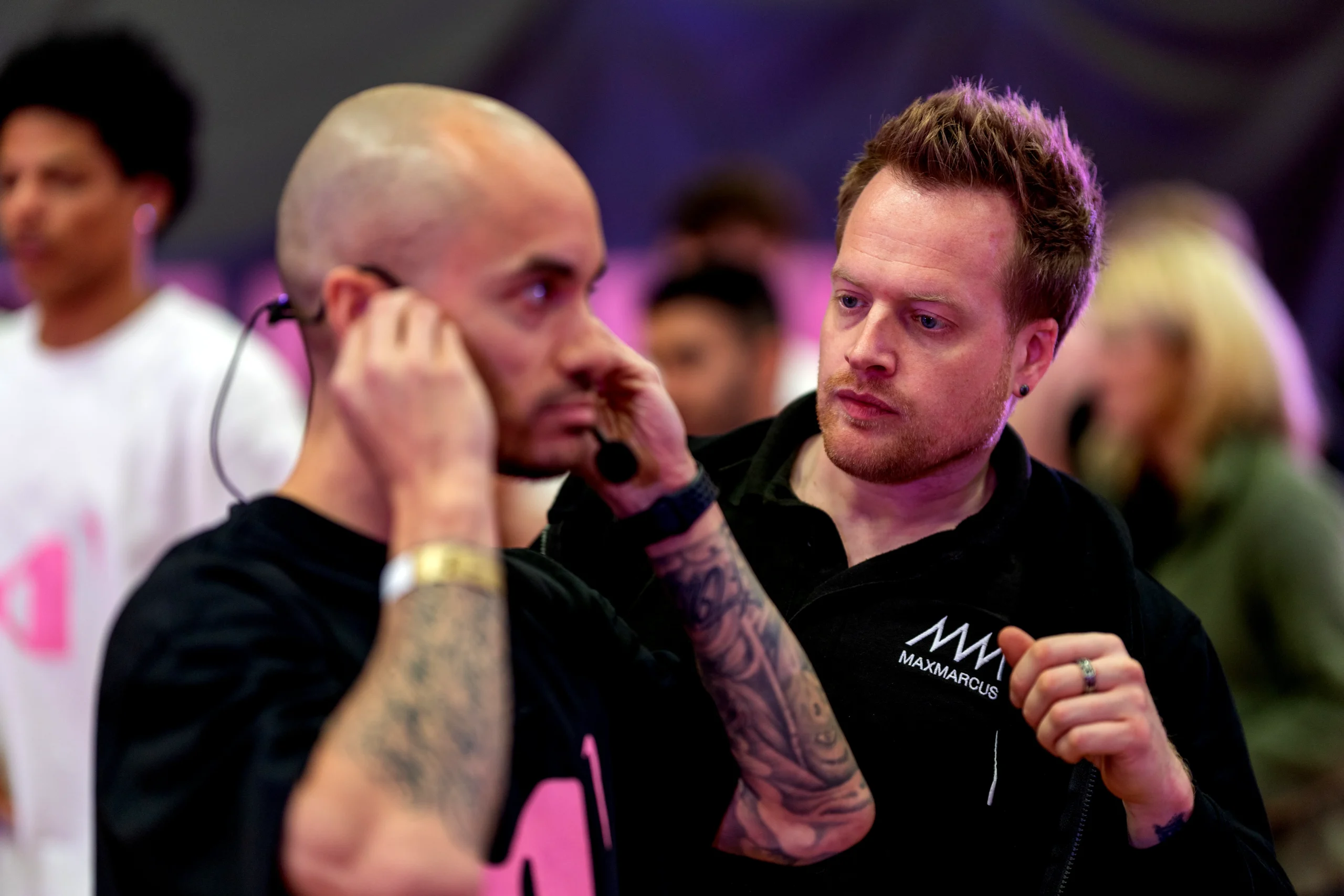 Event production crew preparing talent with microphone equipment