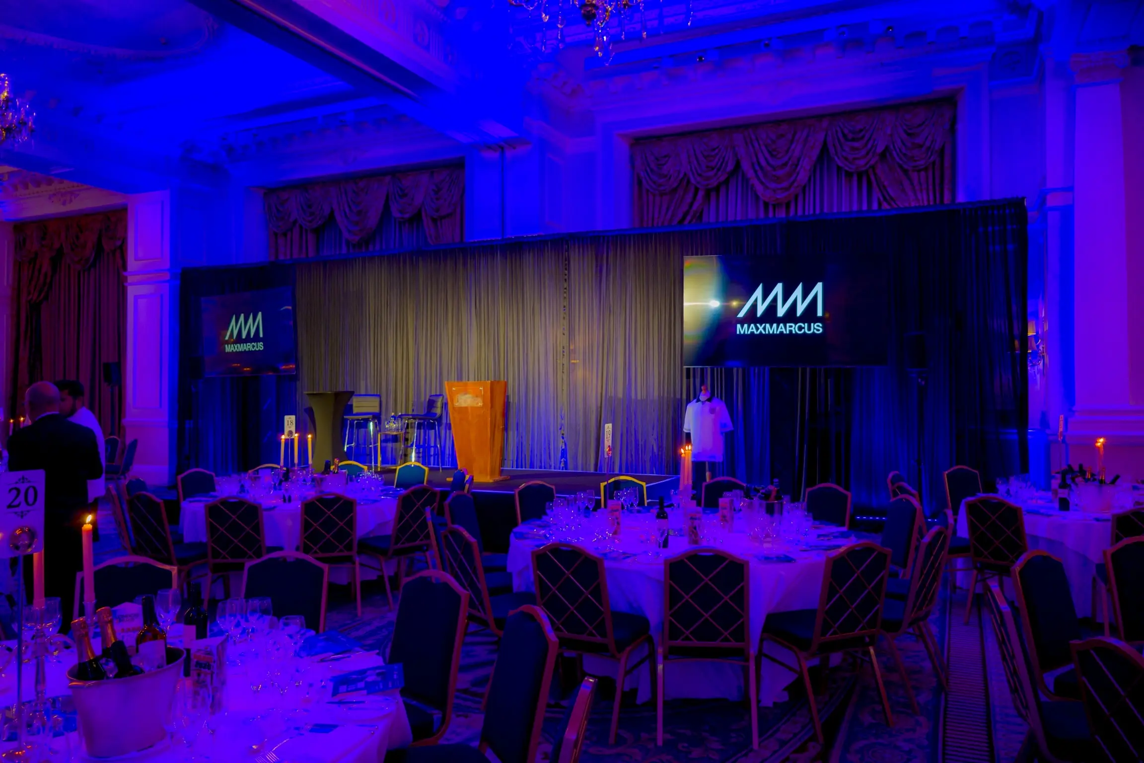 Wireless LED uplighters washing the walls and ceiling of a gala dinner venue in London