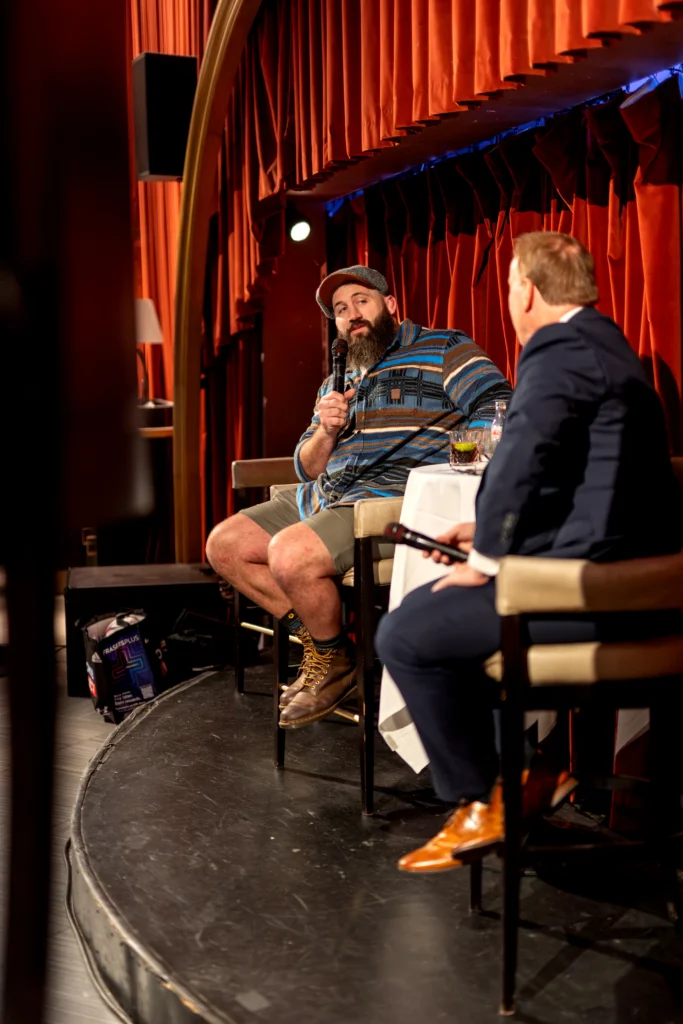 Guest speaker seated on stage with handheld microphone during premium hospitality event