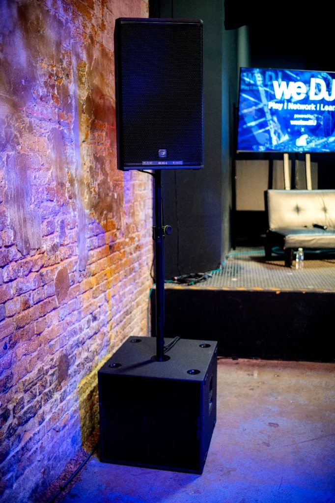 Close-up of the PA speaker stack and subwoofer installation beside the main stage