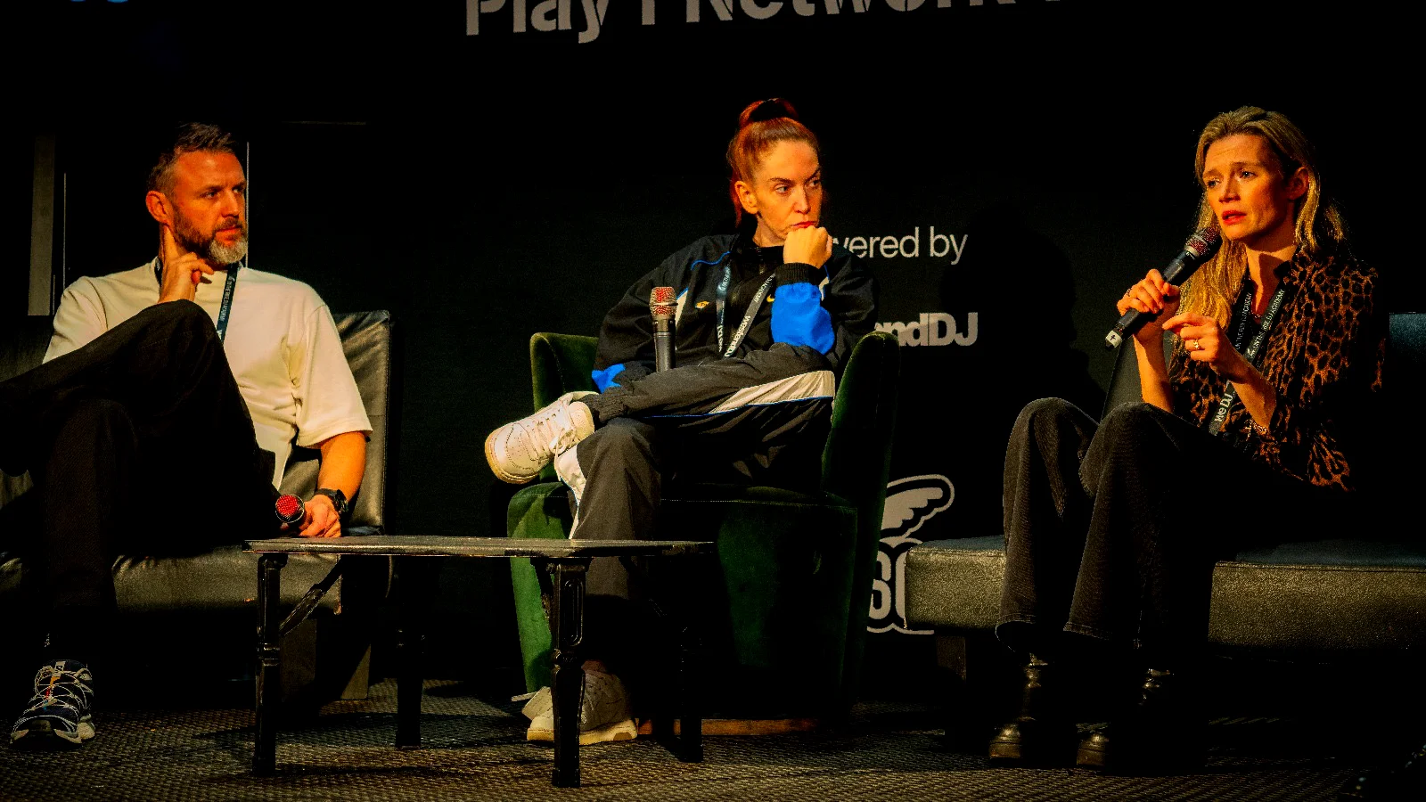 Close-up of speakers during a live panel talk with microphones and stage furniture