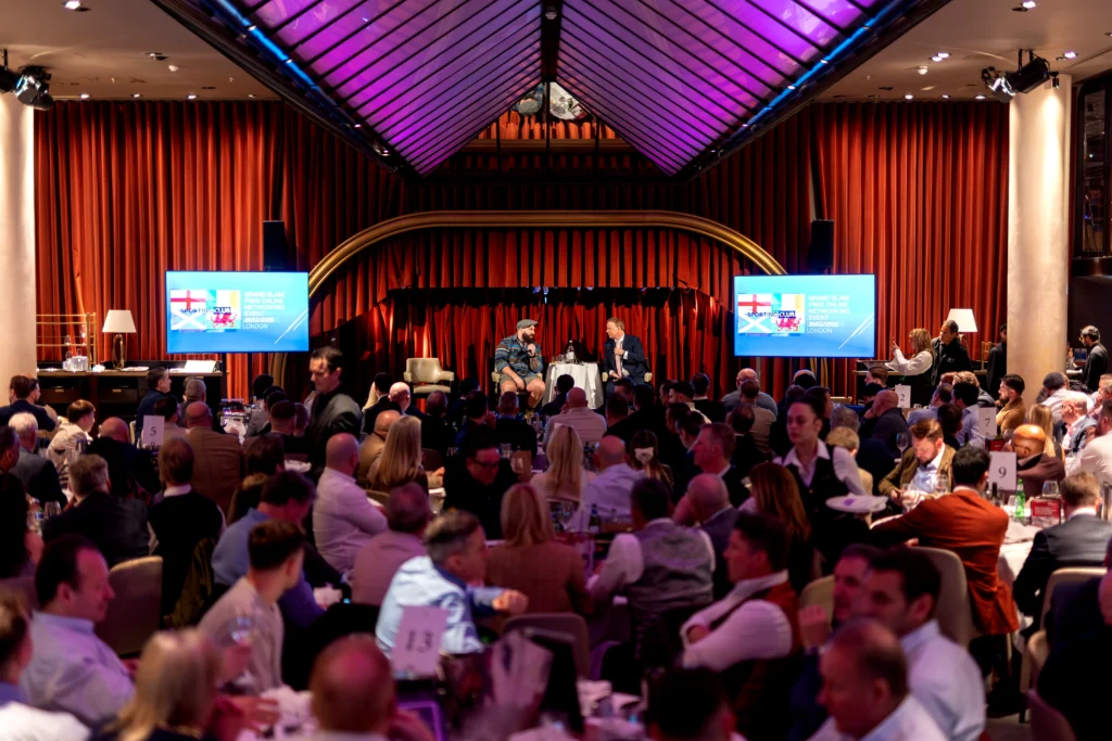 Wide shot of premium hospitality venue with staged speaker setup and audience seating