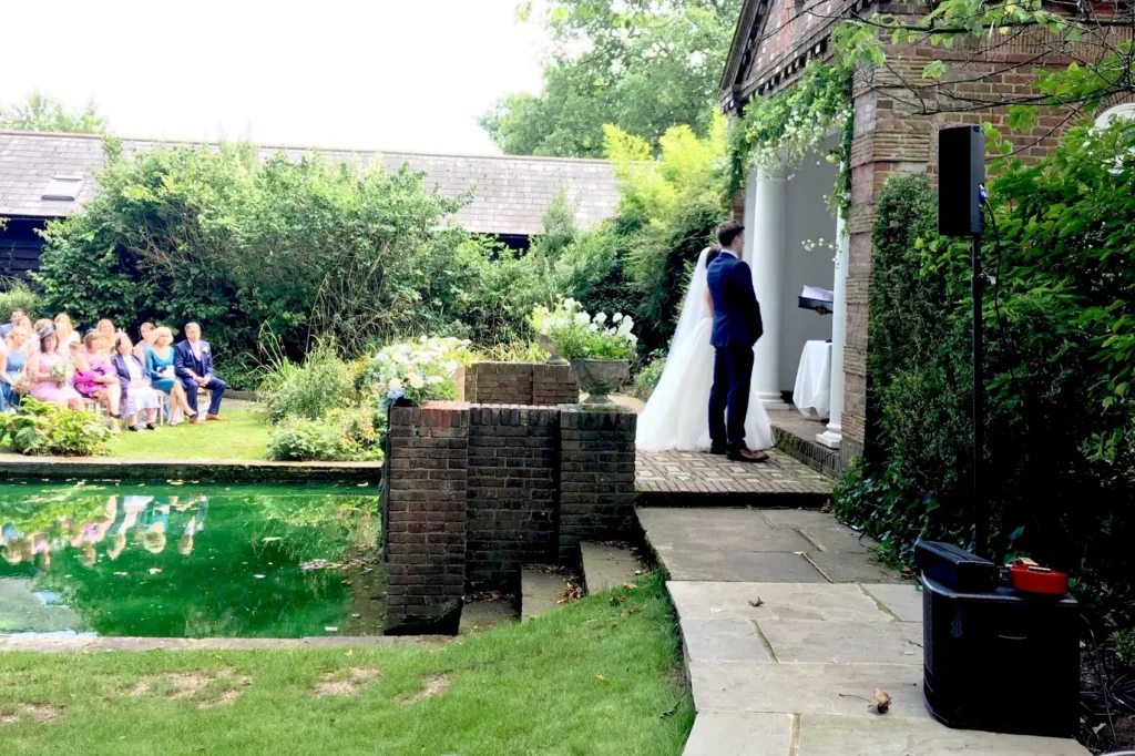Outdoor wedding ceremony with professional sound setup and seated guests