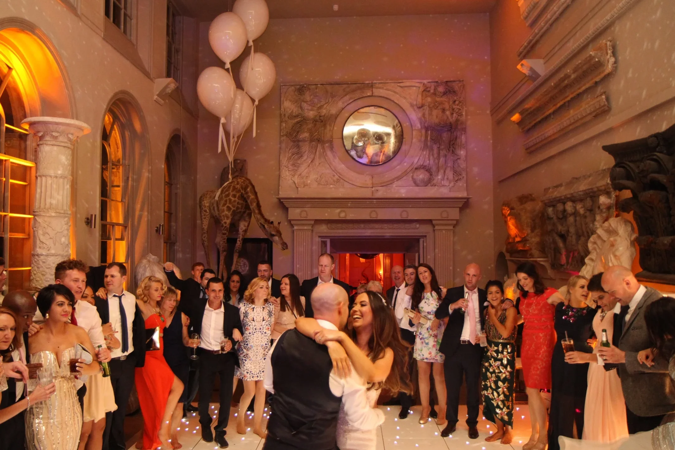 Bride and groom dancing with guests at a wedding reception at Aynhoe Park