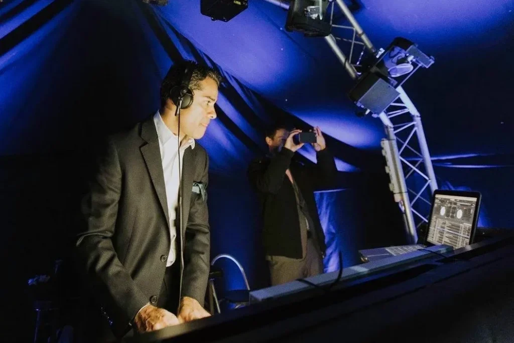 Professional wedding DJ performing at an evening reception with lighting rig