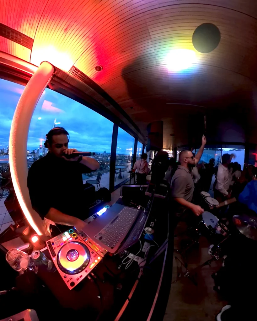 DJ and live percussionist performing at a corporate event with the London skyline in the background.