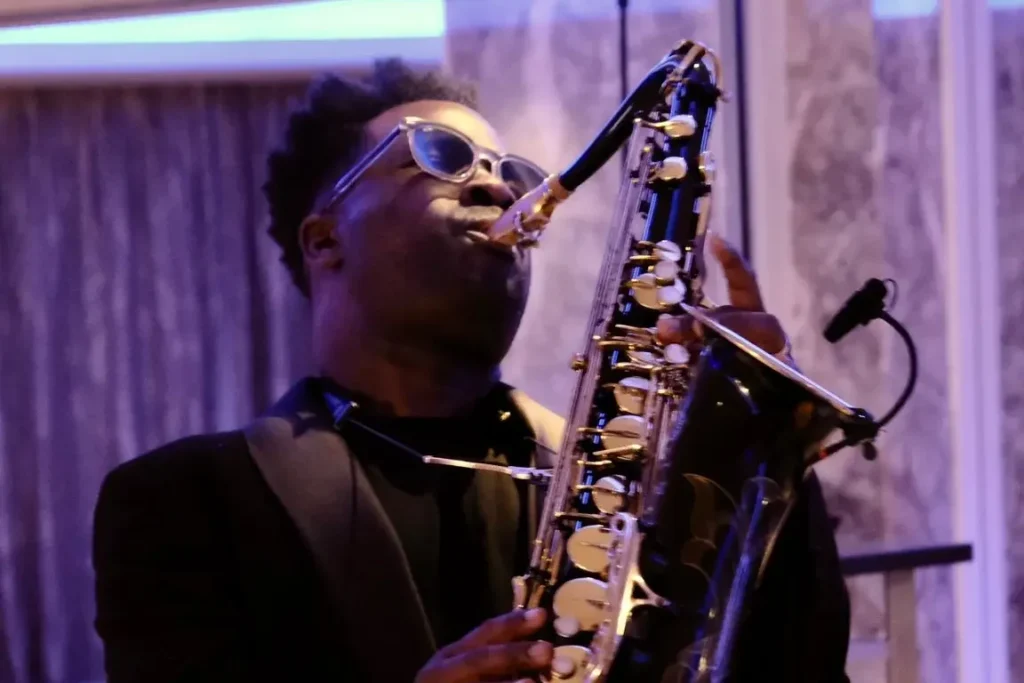 Live saxophonist performing at a corporate gala event in London, providing professional event entertainment with AV production and sound support.