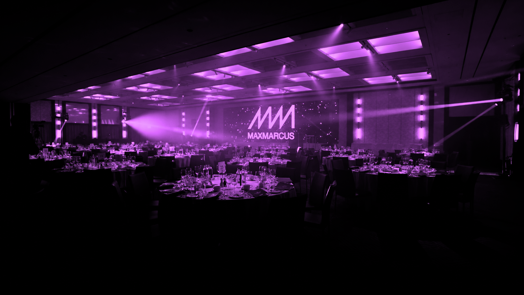 Large-scale event production with lighting, video screen and ballroom setup at a MaxMarcus event in London.